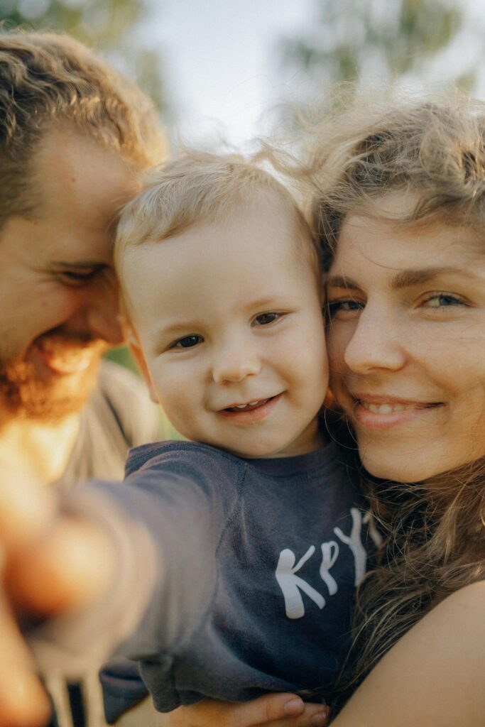 Close-up of a happy family with a smiling child enjoying outdoor time together.